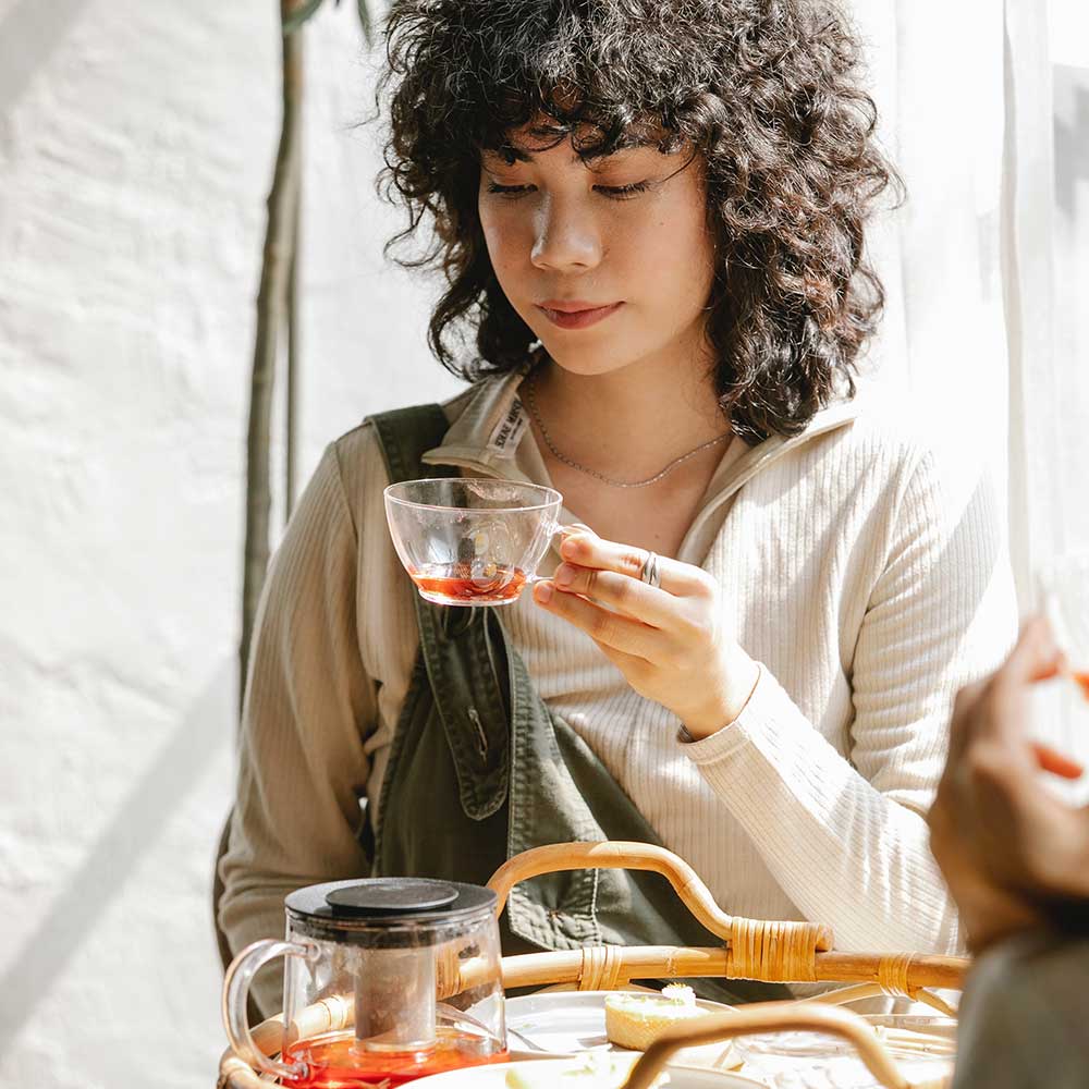 Woman sitting the sun drinking herbal tea