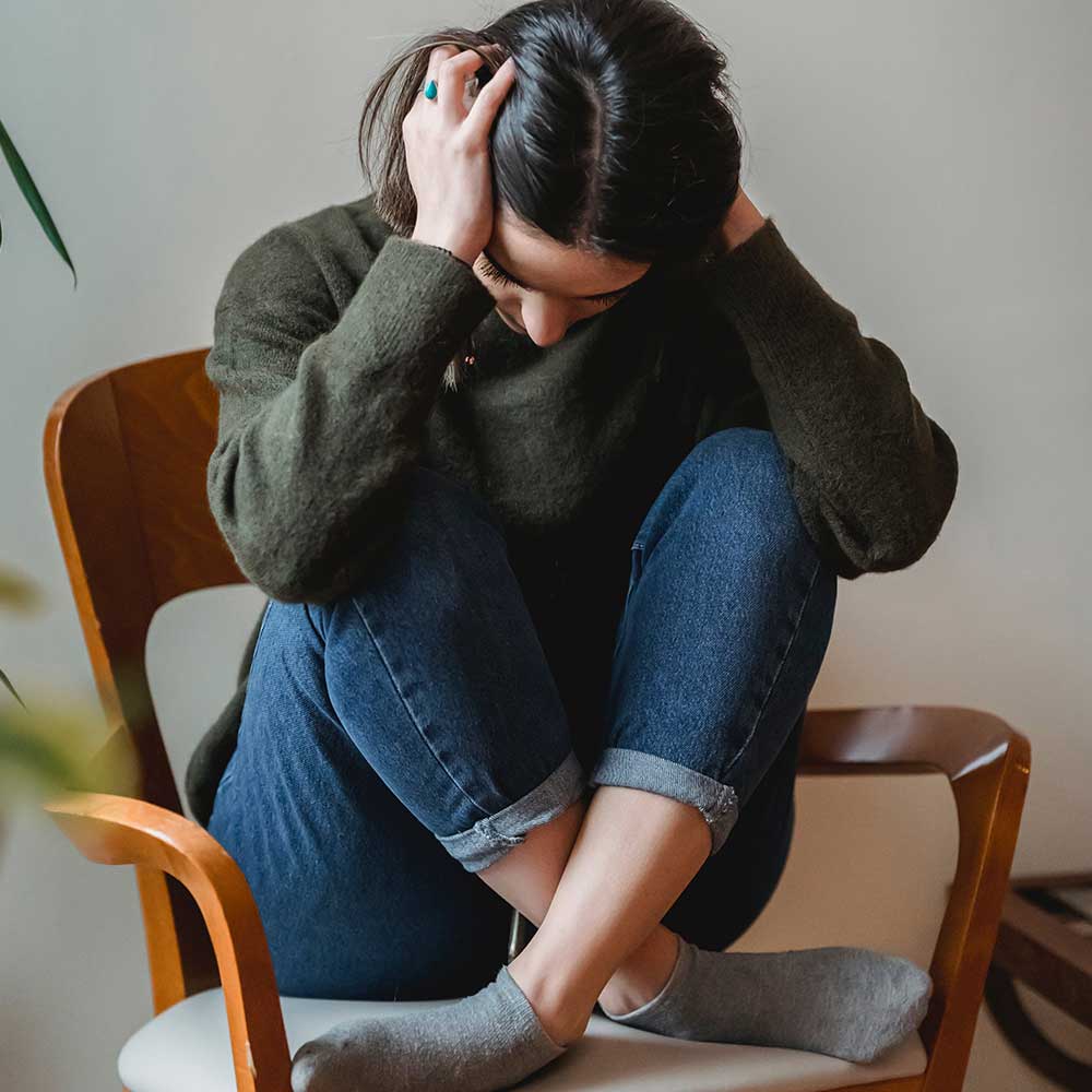 Woman feeling ill sitting in chair