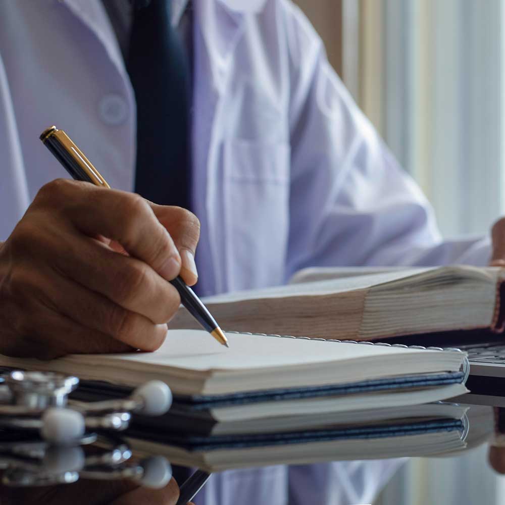 Doctor doing research and taking notes at a desk